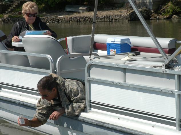 Greg Stoner, a state conservation biologist and advisor to the Lake of the Ozarks Watershed Alliance, collects a water sample while LOWA executive director Donna Swall (left) consults a map of sampling locations on the lake.University of Missouri