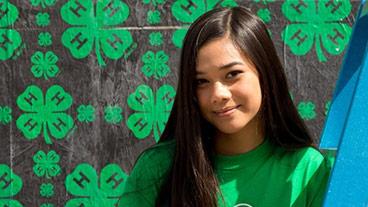 girl in front of 4-H logo background