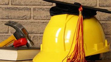 construction hat with graduation cap on top