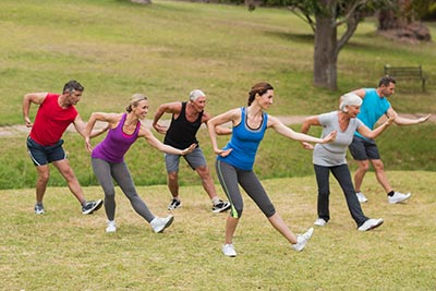 Group practicing tai chi in a sunny field