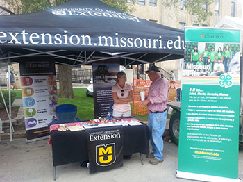 People talking at MU Extension display tent/table