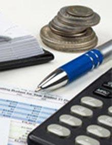 Ledger, calculator, pen and stack of coins.