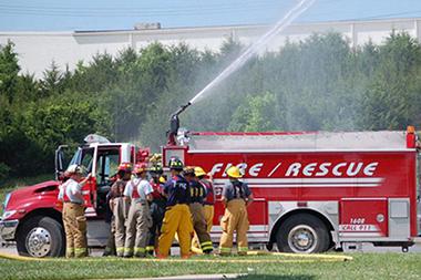 Fire fighters using a truck pump.