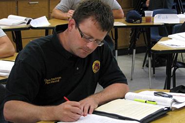 Man in class taking notes.