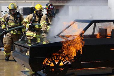 Fire fighters putting out a fire on a training vehicle.