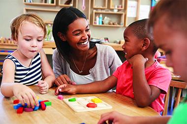 Childcare provider working with children at a table