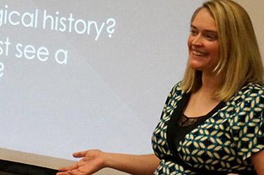 A woman presenting in front of a class.