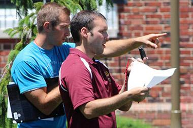 Two men holding papers during a search and rescue.