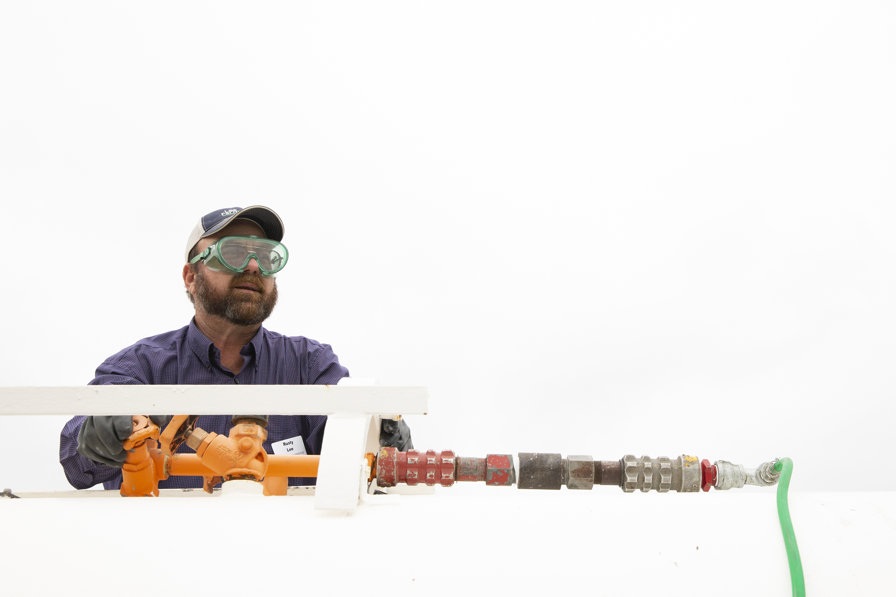 MU Extension agronomist Rusty Lee shows how to slowly add ammonia by cracking the valve on the anhydrous ammonia tank. This allows the ammonia to trickle into the middle of the hay bales overnight. MU Extension file photo.