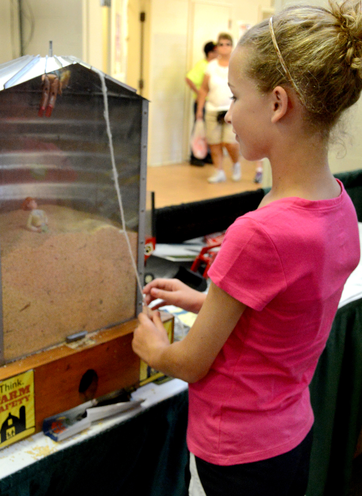 Bonnie Becker, 11,  learned how difficult it is to free someone who is trapped in a grain bin at an exhibit at the  Missouri State Fair. Photo by Emily Kaiser